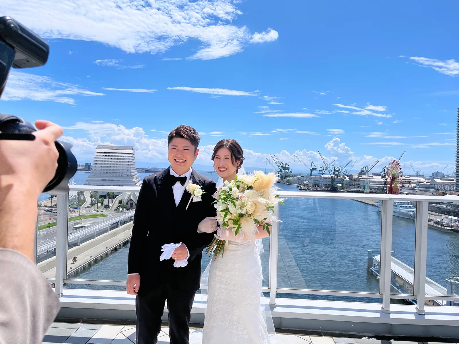 港を望むテラスでブーケを持つ新郎新婦